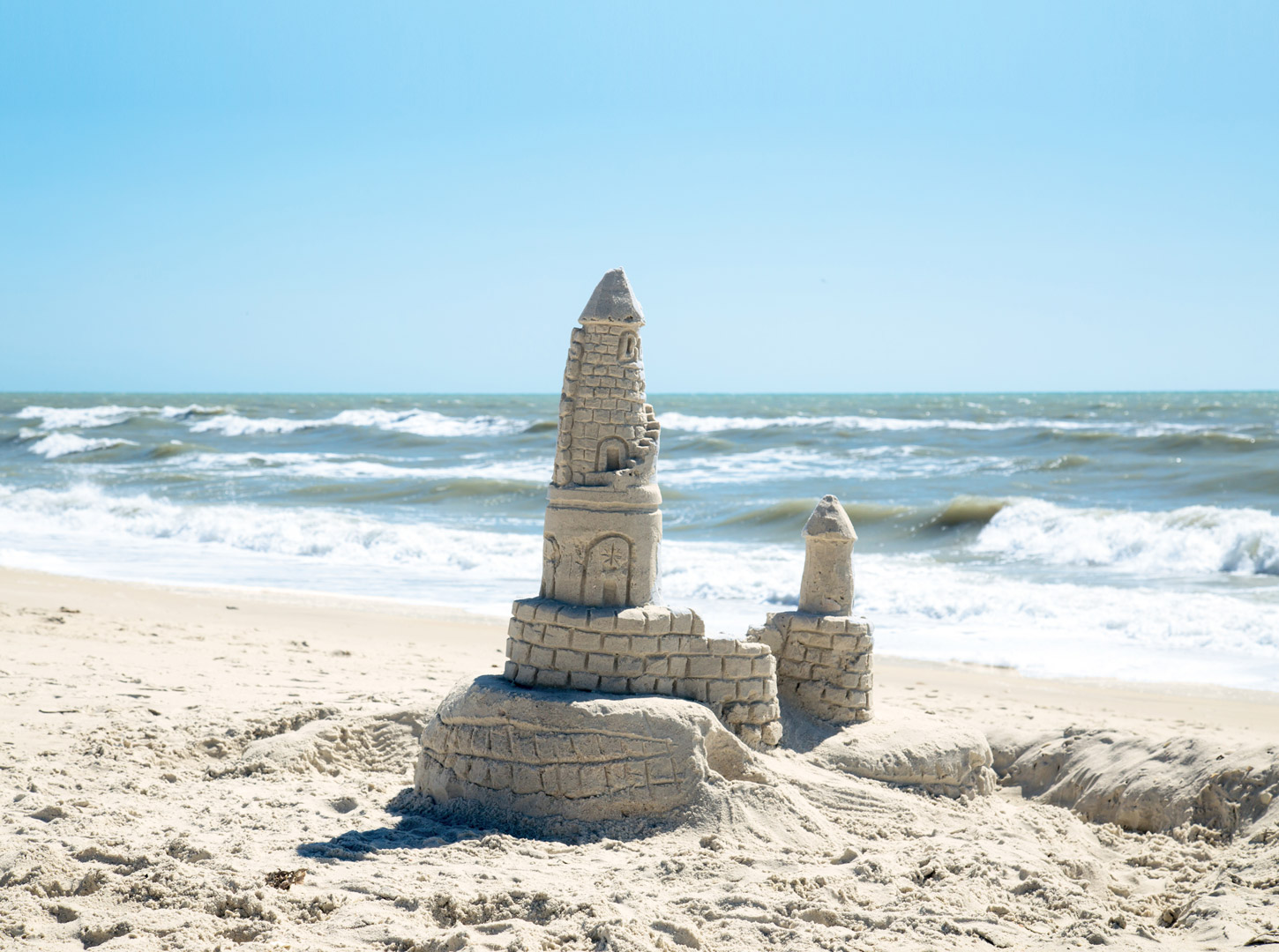 Sandburg_bauen_Meer_Urlaub_Strand_Wellen_Schaum_Sonne_Sommer