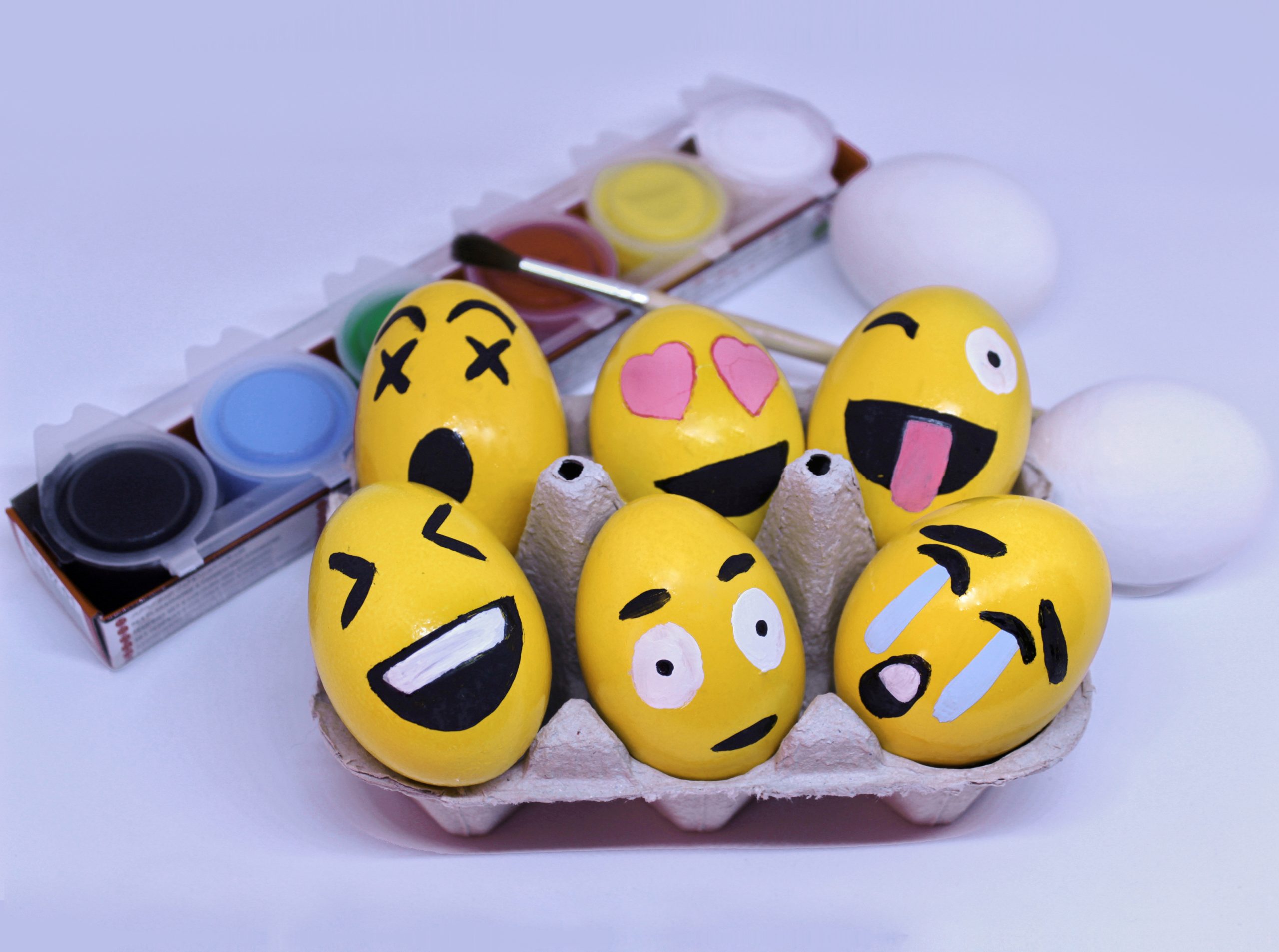 Emoticons Easter Eggs in egg-cup , paints and brush with white background